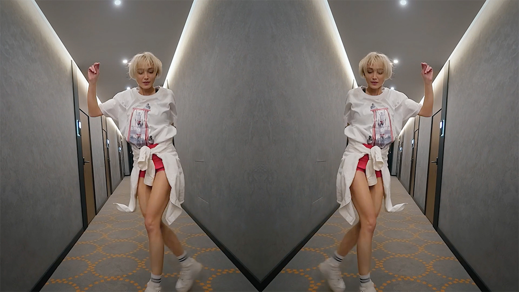 Mirrored image of girl dancing down a hallway